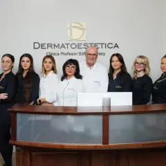 Zespół kliniki dermatologii estetycznej pozuje za ladą recepcyjną.