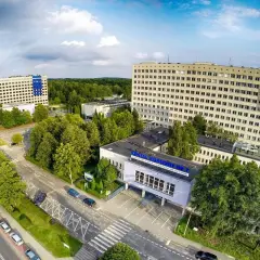 Widok z lotu ptaka na kompleks budynków szpitalnych otoczony zielenią.