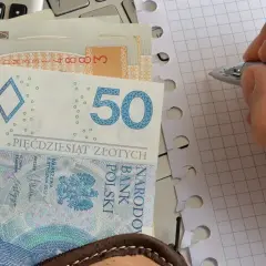 Zasiłek pielęgnacyjny to wsparcie dla osób potrzebujących. Na zdjęciu polskie banknoty, kalkulator i notatnik.