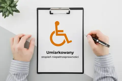 Na tablicy widnieje symbol osoby na wózku inwalidzkim i napis "Umiarkowany stopień niepełnosprawności".